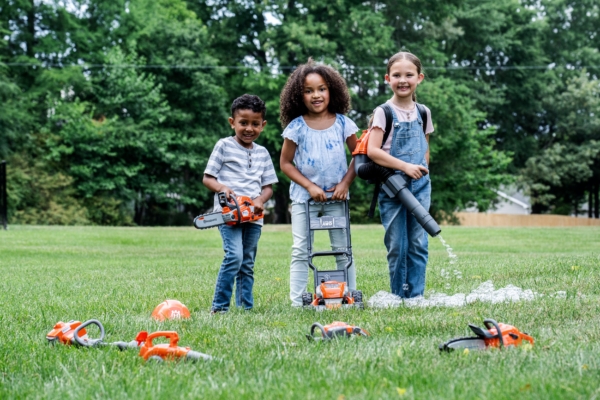 Groepsfoto kinderen spelen met husqvarna speelgoed